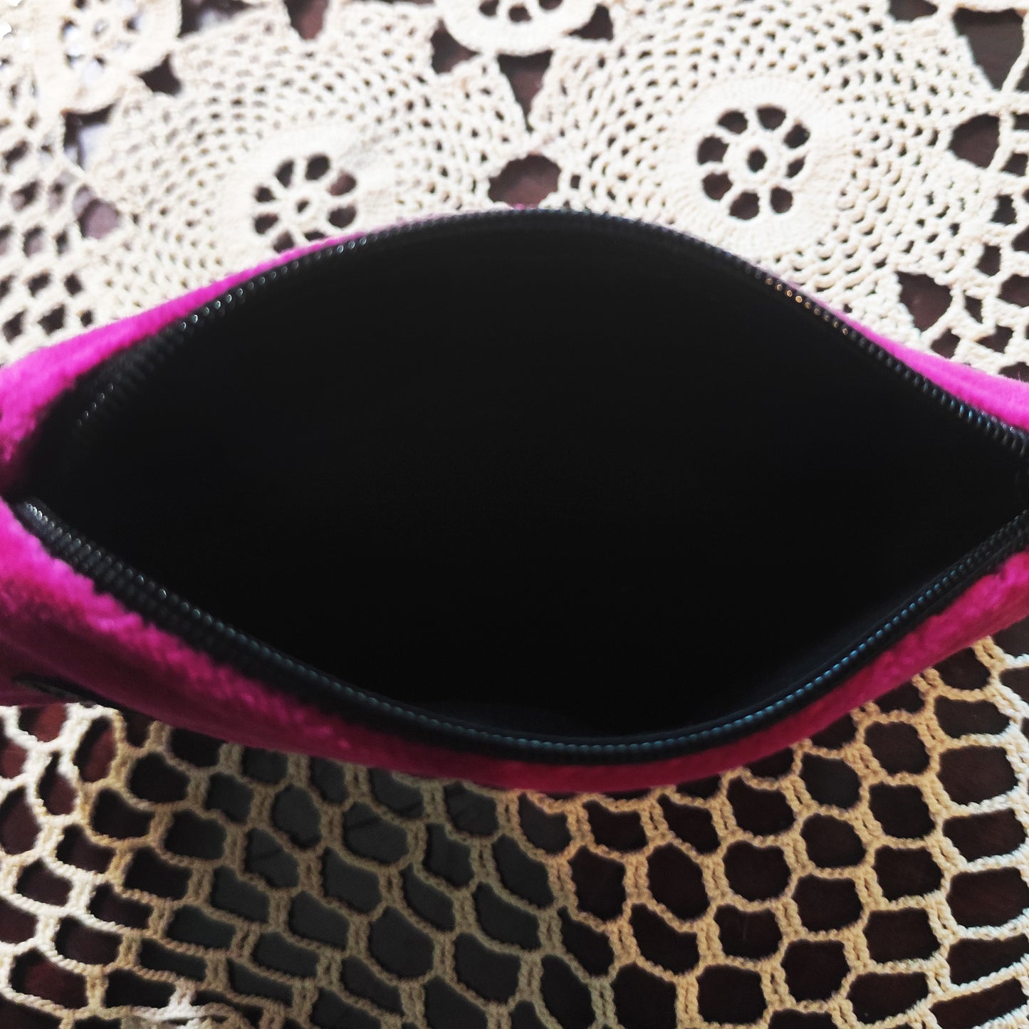 pinkes Schminktäschchen aus weichem Samt. Es ist Sargförmiges schließt mit einen Reißverschluss und es hat drauf genähte Fledermäusen in unterschiedlichen Größen.