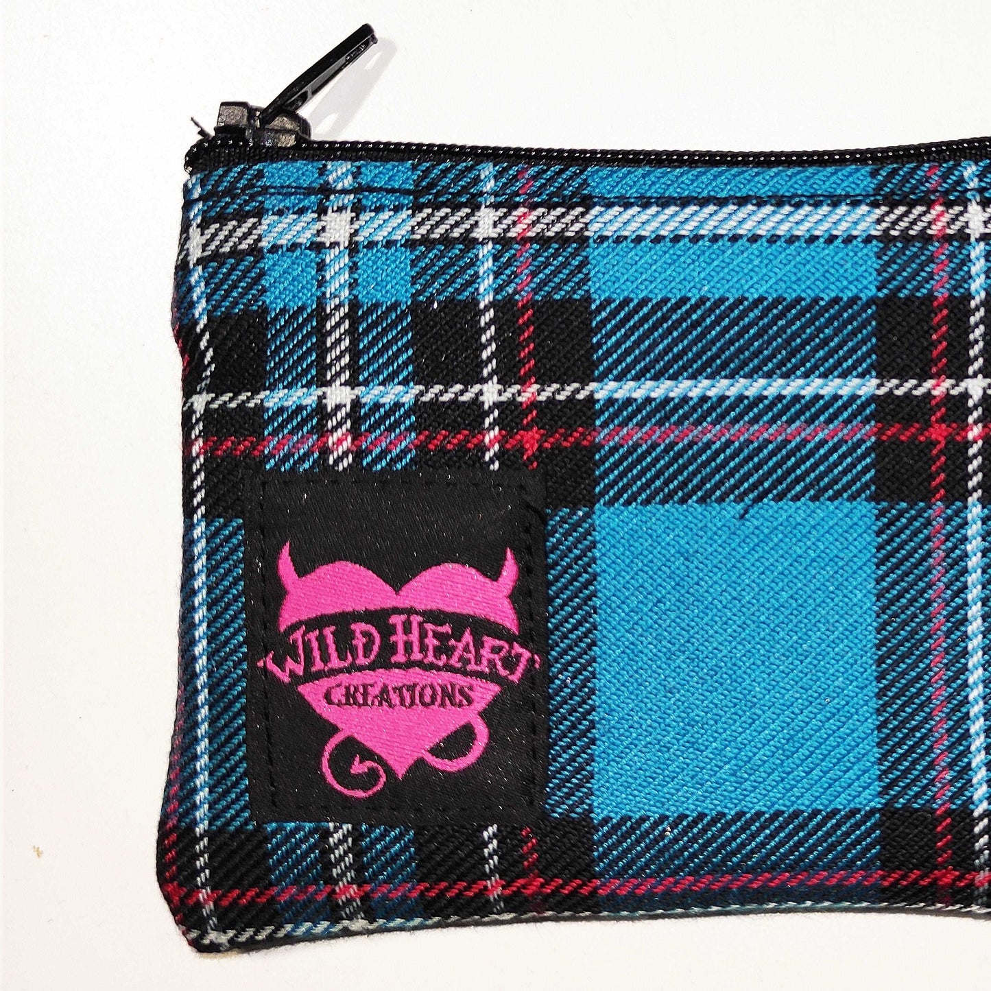 Eine kleine, handliche Münztasche im türkisfarbenen Schottenkaro Muster, das perfekt in jede Handtasche passt.