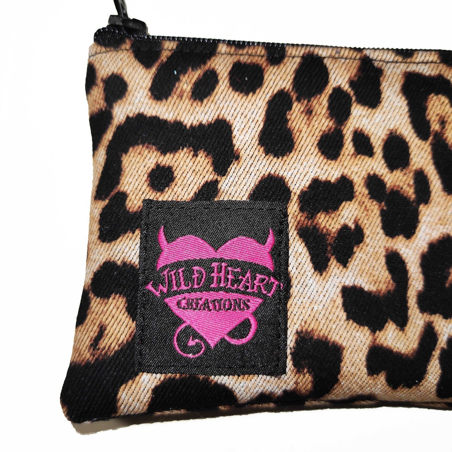 Kleine Münztasche in braunem Leoparden Muster. Sie schließt mit einem Reißverschluss und hat einen Ring für deine Schlüssel an der einen Seite.