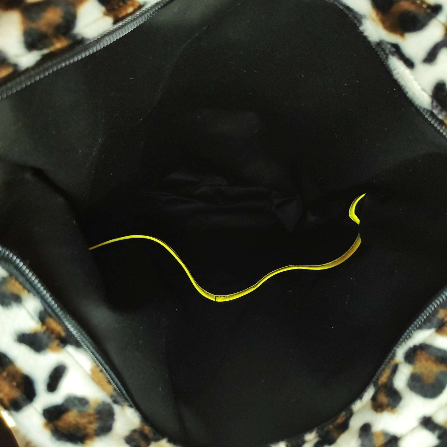 Schnee-Wildkatze Fellimitat kombiniert mit einem Lederimitat in leuchtendem Gelb. Praktische Tasche mit der perfekten Größe, um deine wichtigsten Alltags-Sachen immer dabei zu haben.