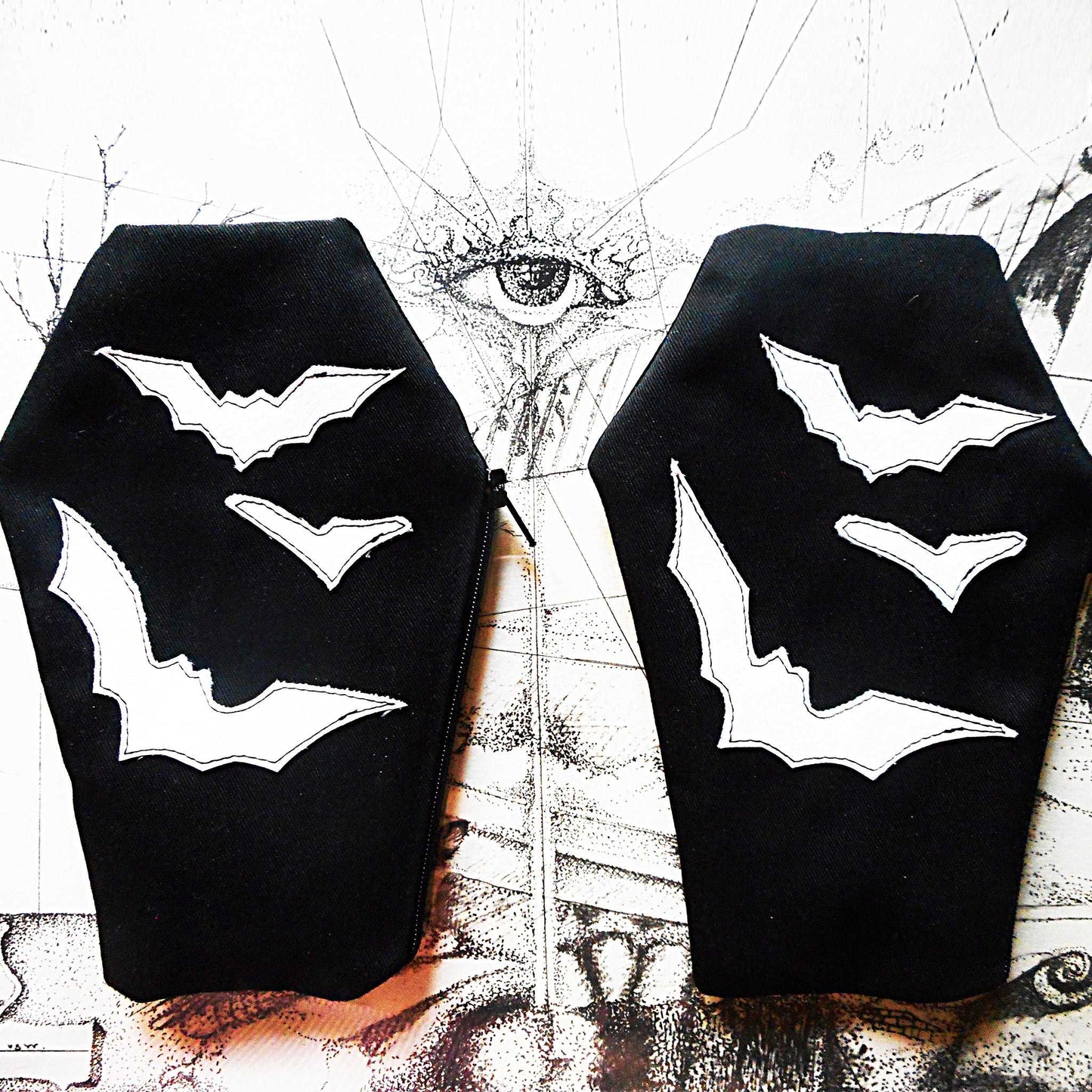 Sargförmiges Reißverschluss Täschchen aus schwarzen Gabardine Stoff mit darauf genähten Fledermäusen in unterschiedlichen Größen.