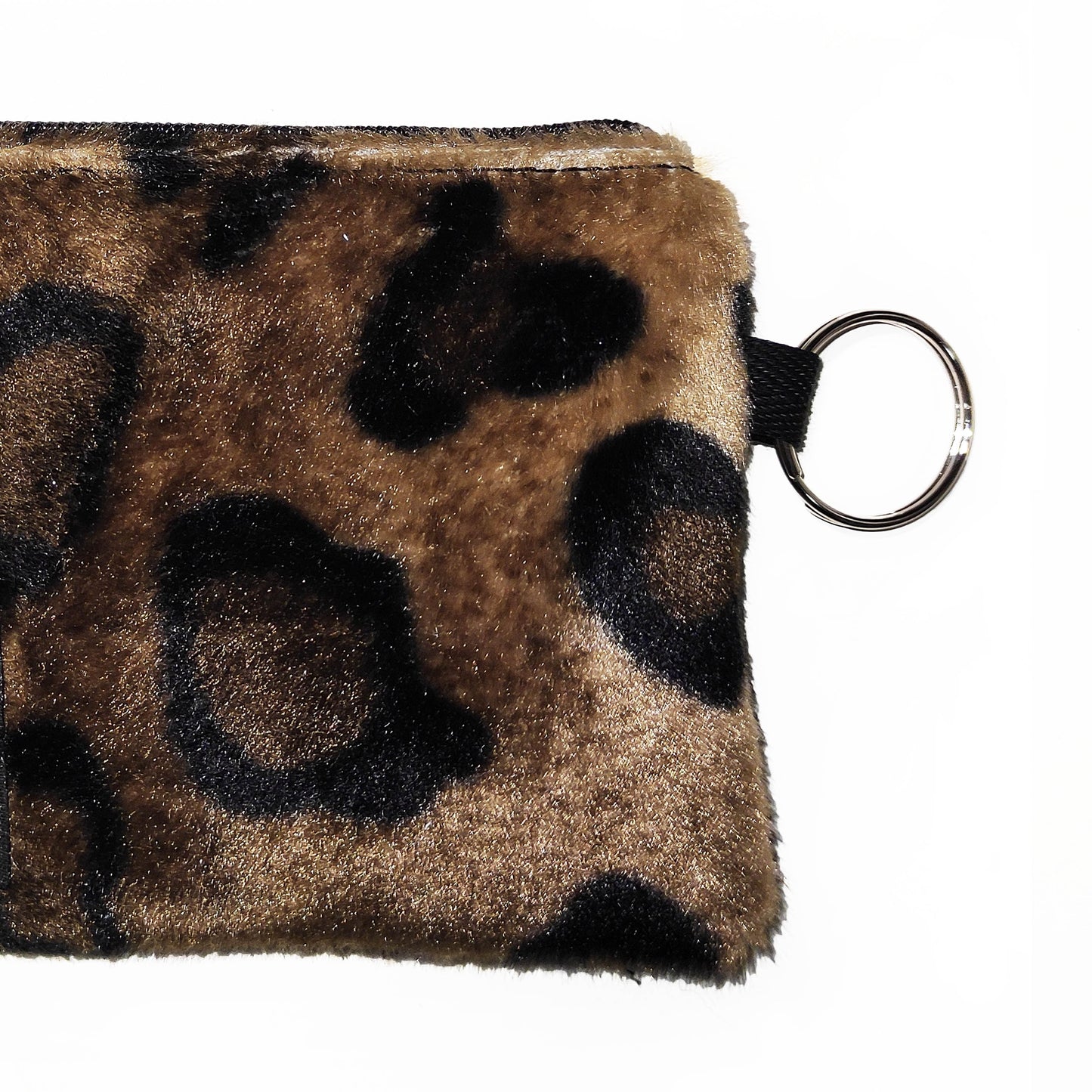 Kleine Münztasche in Leopard Fellimitat schließt mit einem Reißverschluss und hat einen Ring für deine Schlüssel an der einen Seite.
