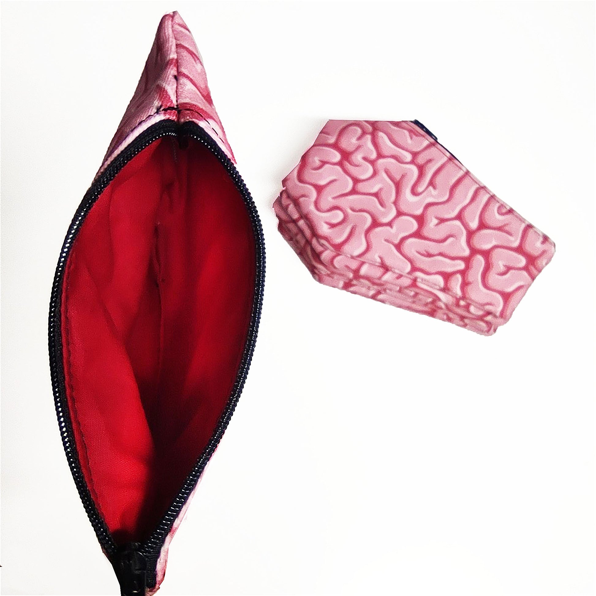 Süße kleine Tasche in Sargform aus rosa Stoff mit Zombie-Gehirn-Motiv und rotem Innenfutter.
