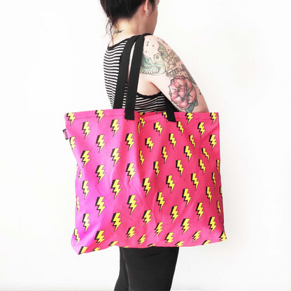 Shopper Tasche mit auffälligen Blitzmotiv auf leuchtend pinkem Hintergrund.