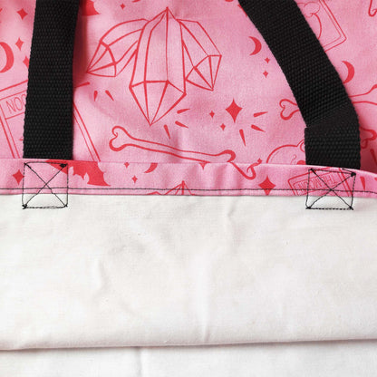 Eine tolle Shopper-Tasche, mit Wicca- und spirituellen Elementen. Das Design umfasst Totenköpfe, Knochen, Fledermäuse, Edelsteine und Tarotkarten auf einem rosa Hintergrund.