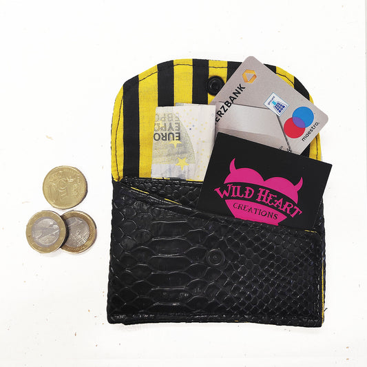 Ein bezauberndes kleines Portemonnaie in schwarzem Krokodil-Lederimitat welches mit  einem praktischen Snap Button schließt. Es bietet zwei Fächer, perfekt für deine Bank- und Visitenkarten sowie Geldscheine. Wähle aus verschiedenen Futterstoff-Mustern deine bevorzugte Option aus.
