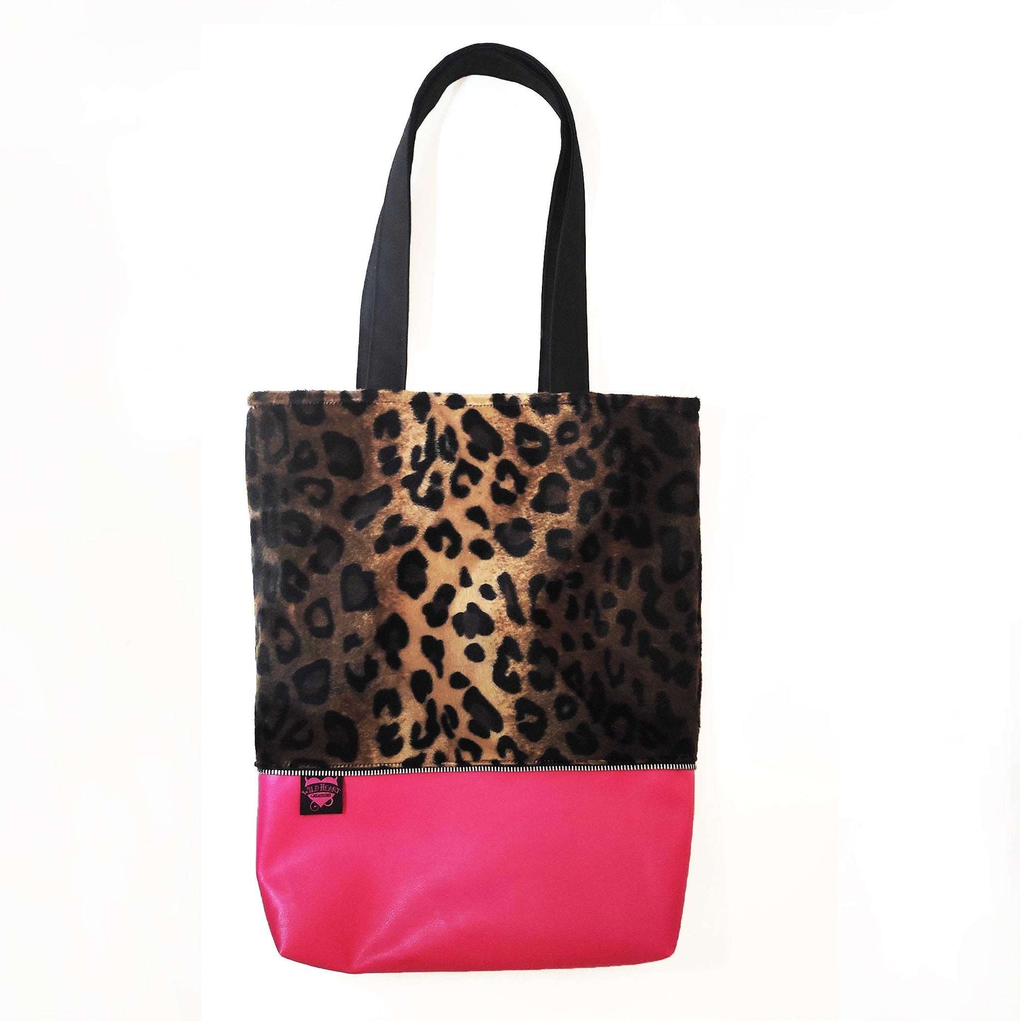 Klassisches Leoparden Muster aus Fellimitat kombiniert mit pinkem Kunstleder und dekorativen Metall Reißverschluss außen herum. 